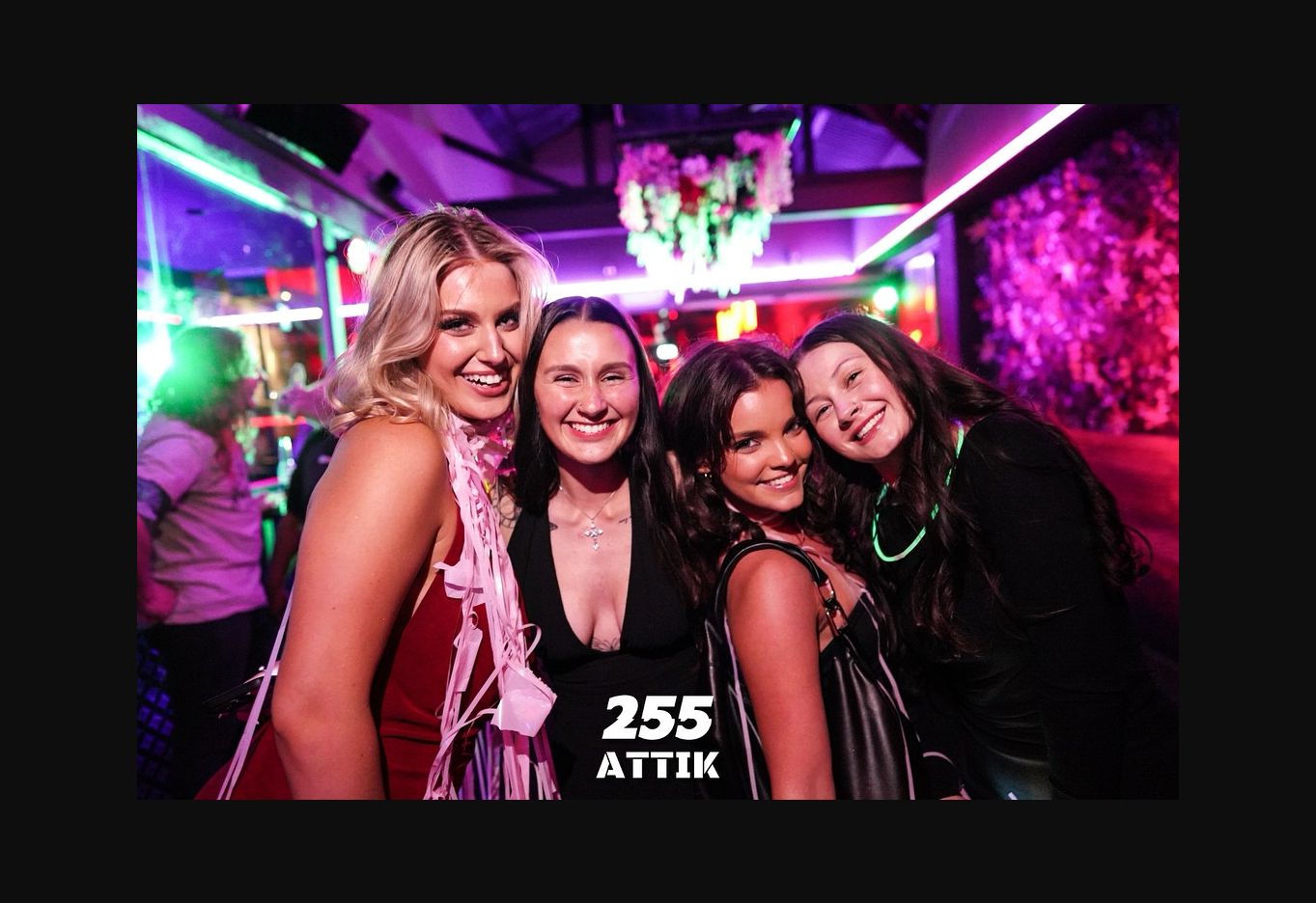 A group enjoying ATTIK under purple lighting