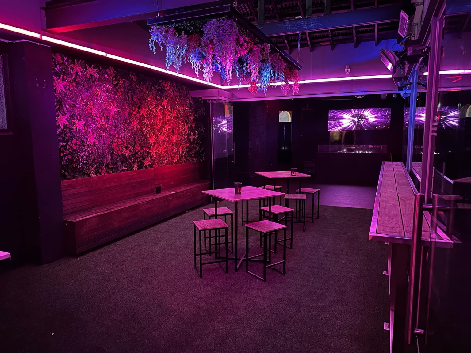 ATTIK rooftop with purple lighting and floral features